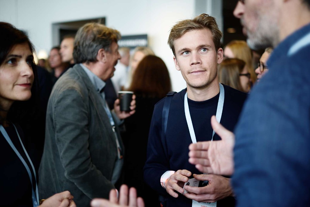 Personer som pratar med varandra under en konferens.