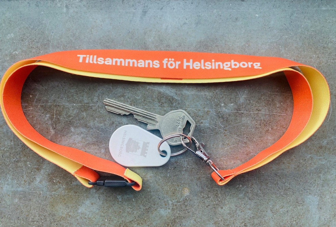 Ett nyckelband med nyckel och tagg